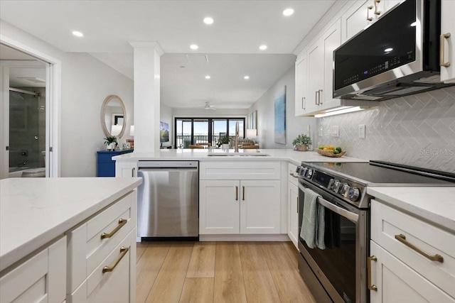 kitchen featuring ceiling fan, sink, light hardwood / wood-style flooring, stainless steel appliances, and white cabinets