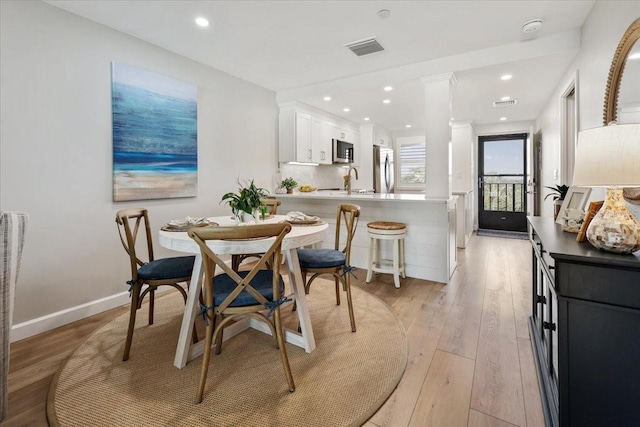 dining space featuring light hardwood / wood-style floors and sink