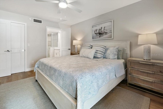 bedroom with ceiling fan, dark hardwood / wood-style flooring, and ensuite bathroom