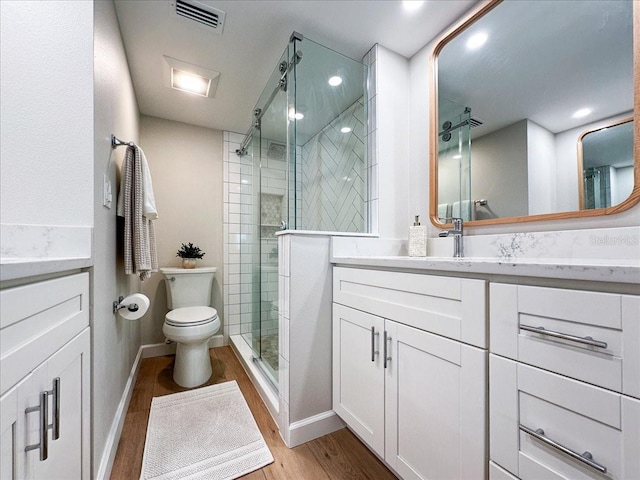 bathroom featuring a shower with shower door, wood-type flooring, toilet, and vanity