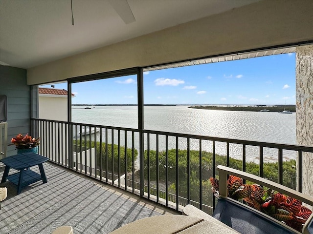 sunroom featuring a water view