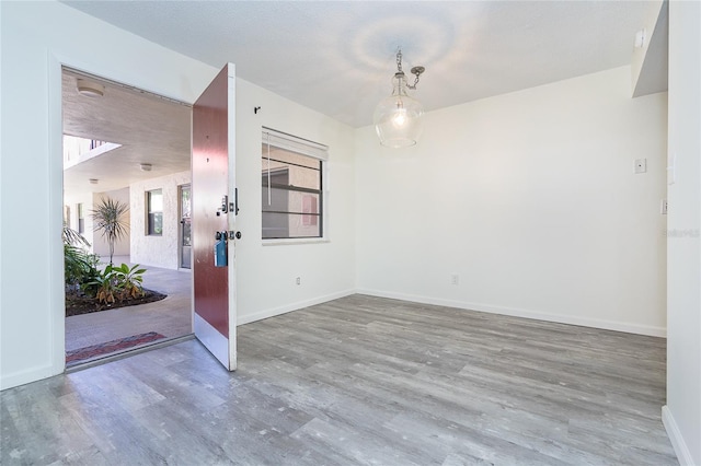 spare room with a healthy amount of sunlight and hardwood / wood-style floors