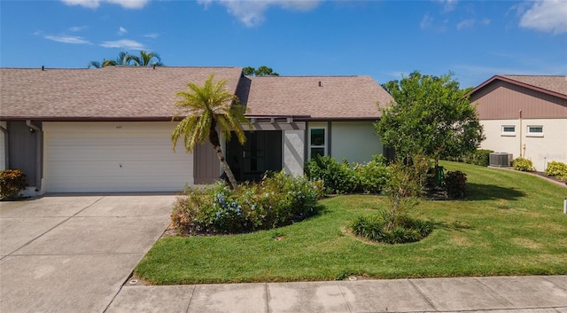 ranch-style house featuring a front lawn, cooling unit, and a garage