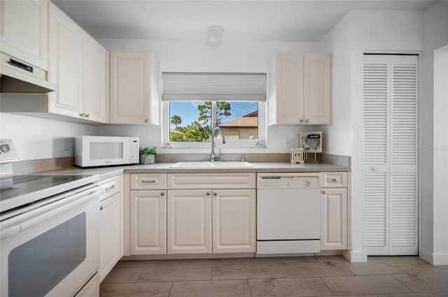 kitchen featuring white appliances, white cabinetry, and sink