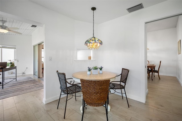 dining area with ceiling fan with notable chandelier and light hardwood / wood-style floors