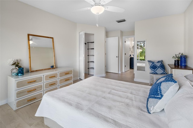 bedroom with ceiling fan, light hardwood / wood-style floors, connected bathroom, and a closet