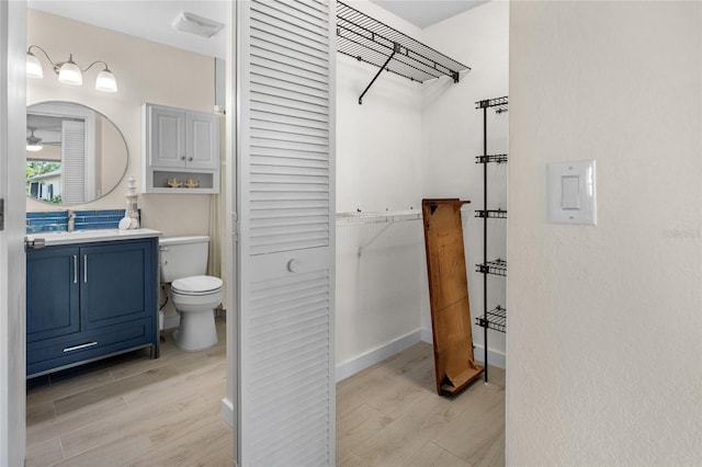 bathroom featuring toilet, vanity, and hardwood / wood-style floors