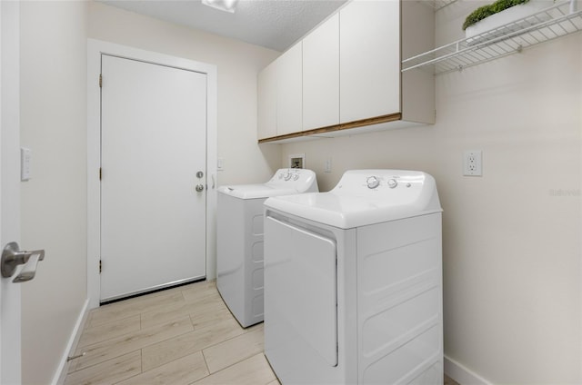 washroom featuring a textured ceiling, cabinets, and independent washer and dryer