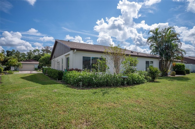 view of side of home featuring a lawn and a garage