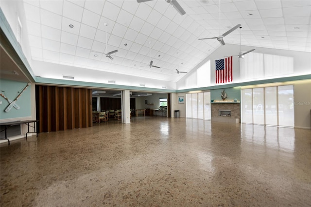 interior space featuring a paneled ceiling, a high ceiling, and ceiling fan