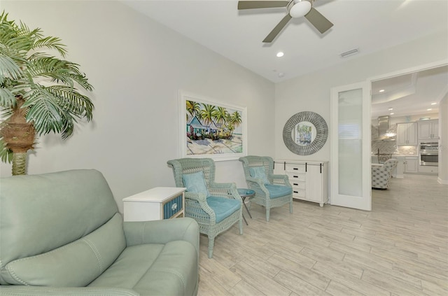 sitting room with light hardwood / wood-style floors and ceiling fan