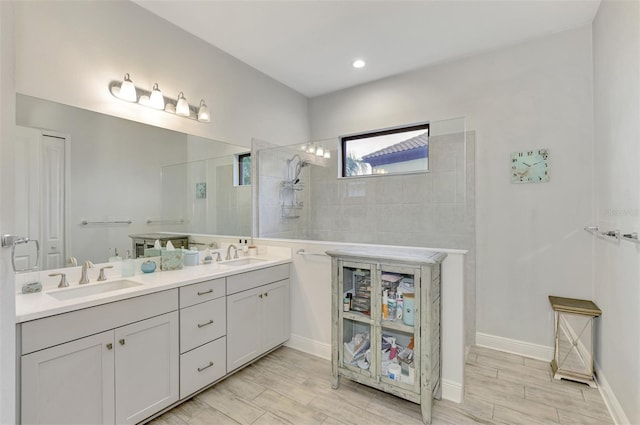 bathroom with tiled shower and vanity