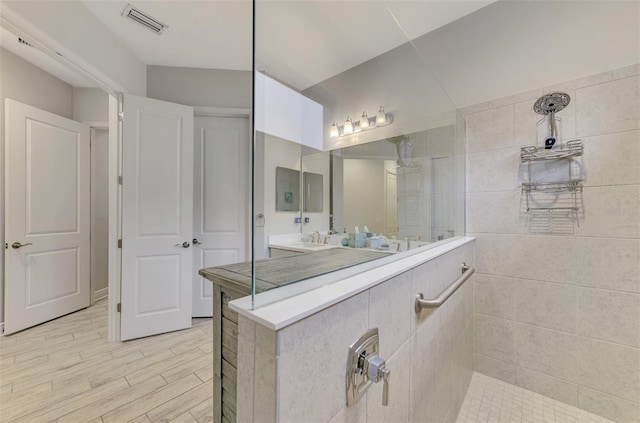 bathroom featuring a shower, hardwood / wood-style flooring, and vanity