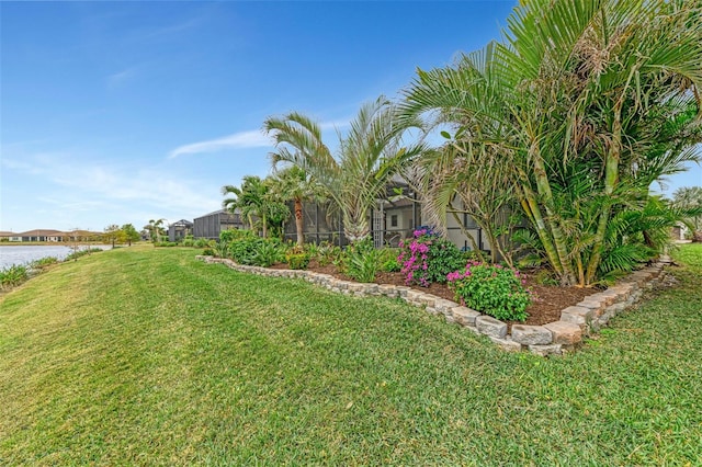 view of yard featuring a lanai and a water view