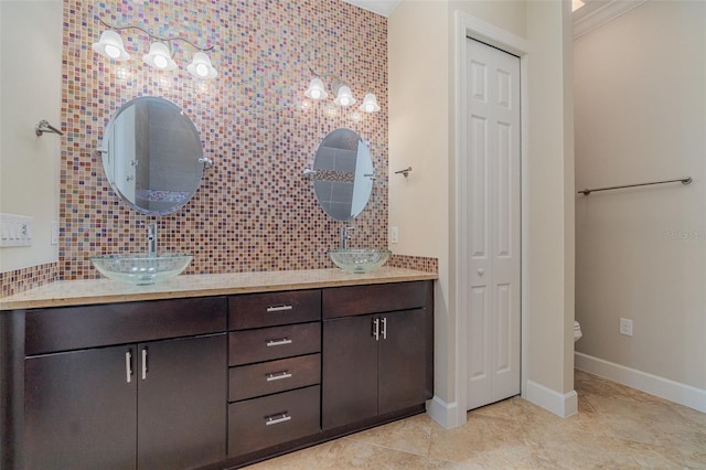 bathroom with toilet, decorative backsplash, tile patterned flooring, crown molding, and vanity