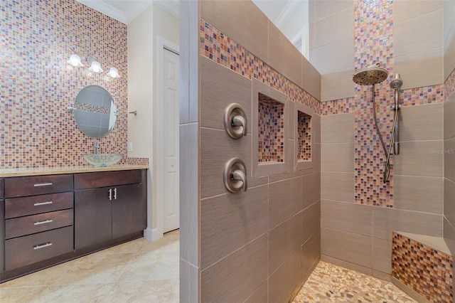 bathroom featuring vanity, ornamental molding, and tiled shower