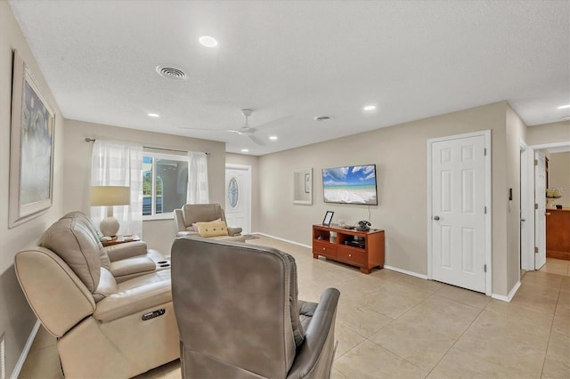 tiled living room with ceiling fan and a textured ceiling