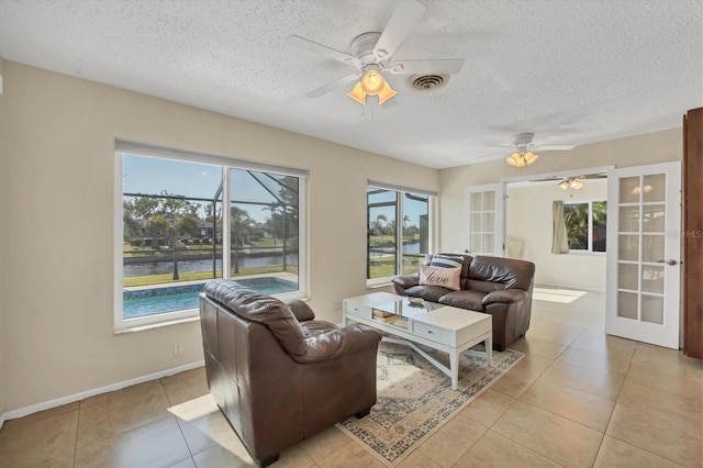 living room with french doors, light tile patterned flooring, and a healthy amount of sunlight