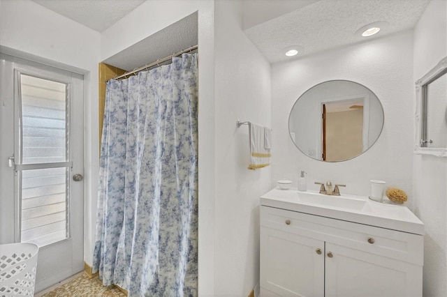 bathroom featuring curtained shower, vanity, and a textured ceiling