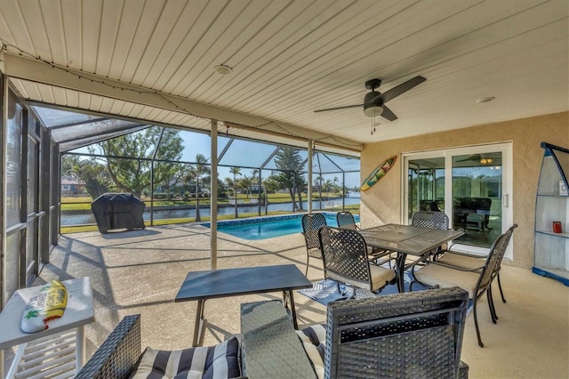 exterior space with a water view, glass enclosure, and ceiling fan