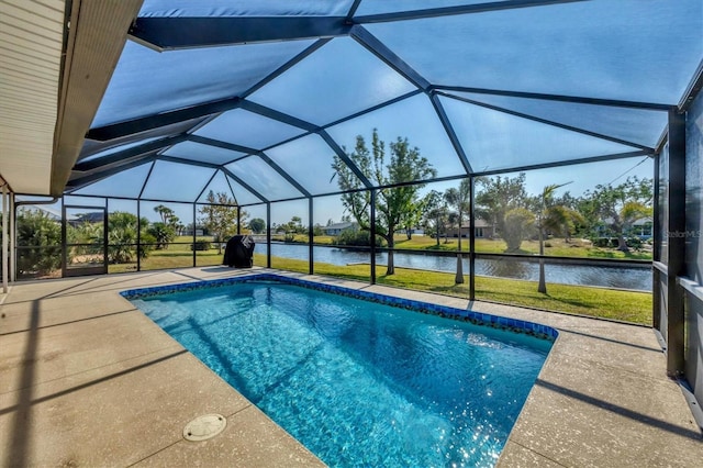 view of swimming pool featuring glass enclosure, a patio area, and a water view