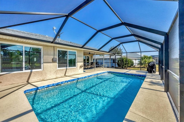 view of swimming pool featuring glass enclosure and a patio area