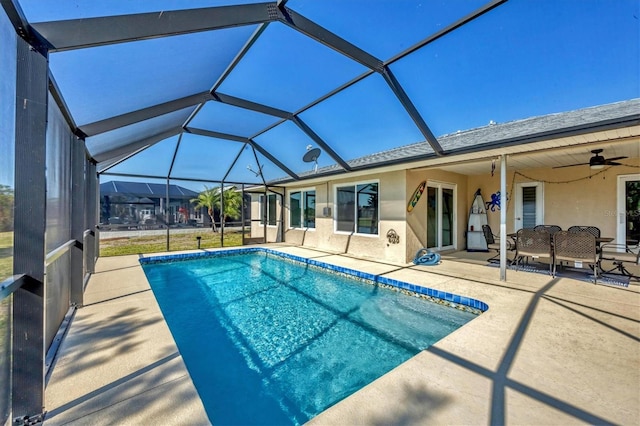 view of pool with ceiling fan, a lanai, and a patio