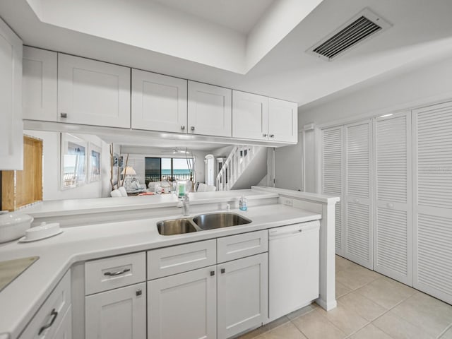 kitchen with white cabinetry, dishwasher, sink, kitchen peninsula, and light tile patterned floors