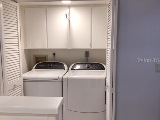 washroom with cabinets and washer and dryer