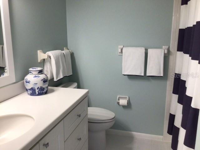 bathroom featuring tile patterned floors, toilet, a shower with shower curtain, and vanity