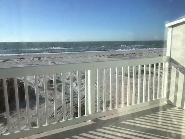 balcony with a water view and a beach view