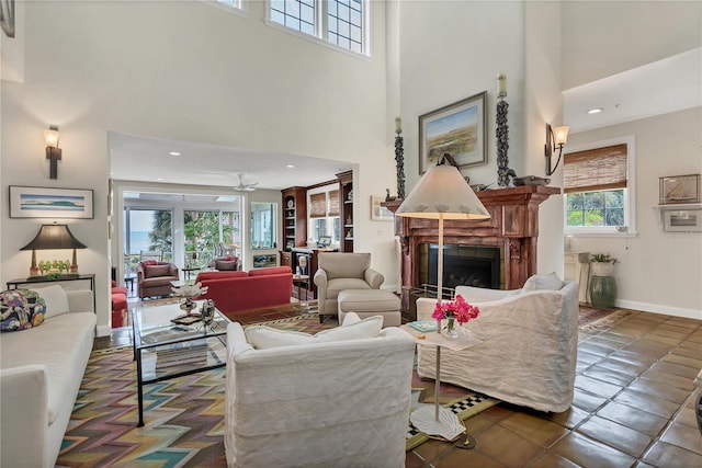 living room featuring ceiling fan and a high ceiling