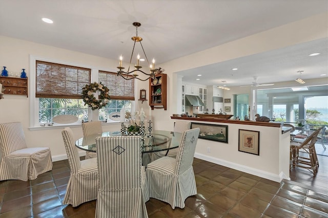 tiled dining area with ceiling fan with notable chandelier