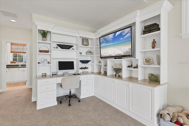 carpeted home office with built in desk