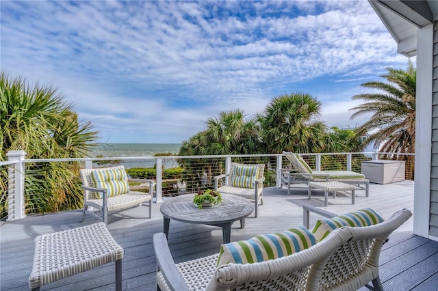 deck with an outdoor living space and a water view