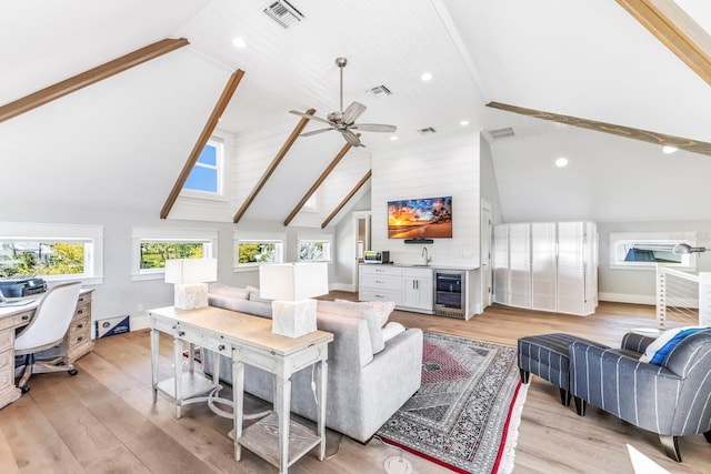 living room with beam ceiling, high vaulted ceiling, light hardwood / wood-style floors, wet bar, and beverage cooler