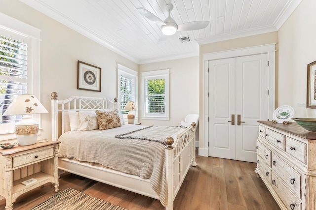 bedroom featuring ornamental molding, ceiling fan, dark wood-type flooring, wooden ceiling, and a closet