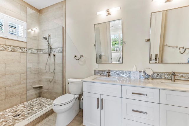 bathroom with a healthy amount of sunlight, vanity, and tiled shower