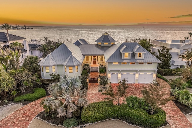 view of front of home with a garage and a water view