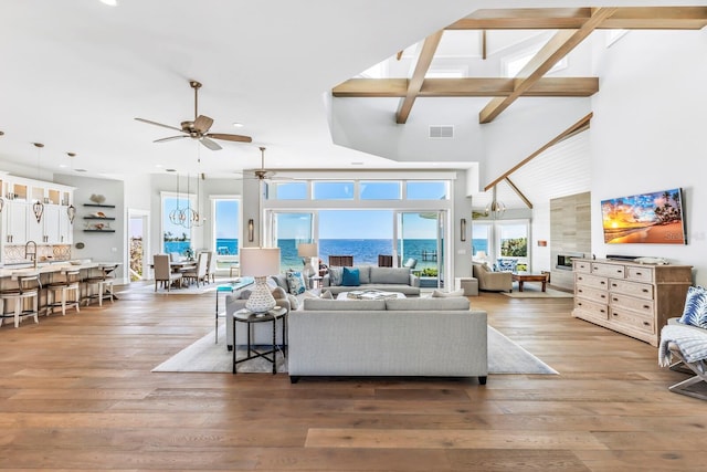 living room with sink, hardwood / wood-style flooring, ceiling fan, and a high ceiling