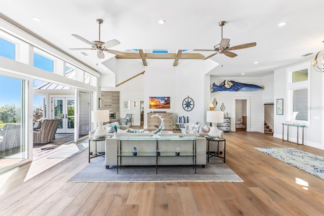 living room with french doors, ceiling fan, a high ceiling, and light wood-type flooring