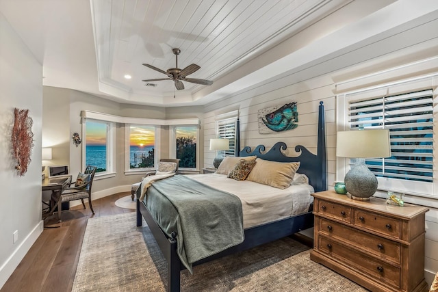 bedroom featuring ceiling fan, dark hardwood / wood-style floors, wood ceiling, and a tray ceiling