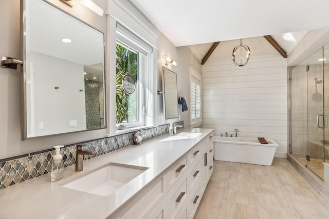 bathroom with vanity, vaulted ceiling, a healthy amount of sunlight, and wood walls