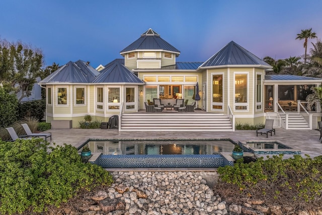 back house at dusk featuring an outdoor hangout area and a patio