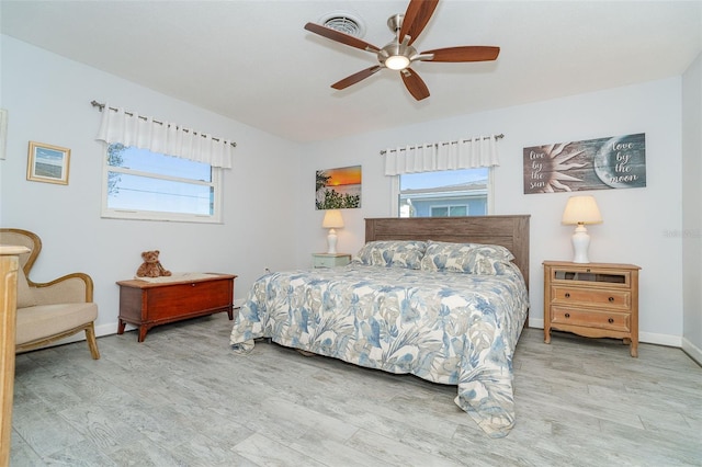 bedroom featuring wood-type flooring, multiple windows, and ceiling fan