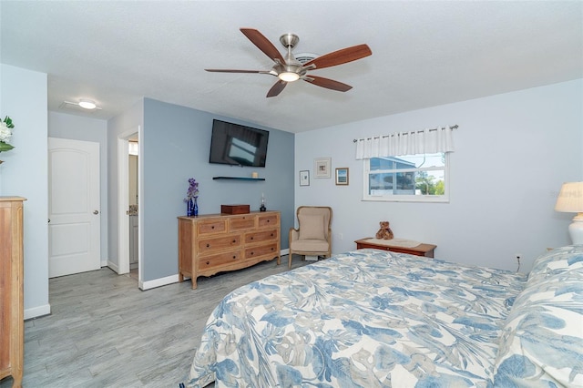 bedroom featuring ceiling fan, light hardwood / wood-style floors, and a textured ceiling