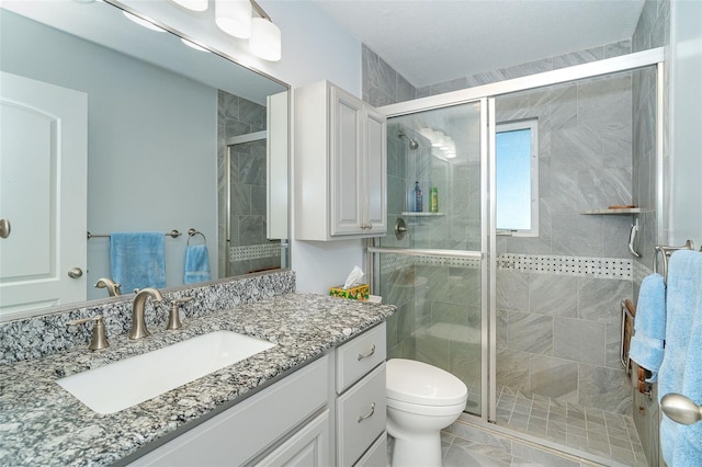 bathroom with walk in shower, vanity, and toilet