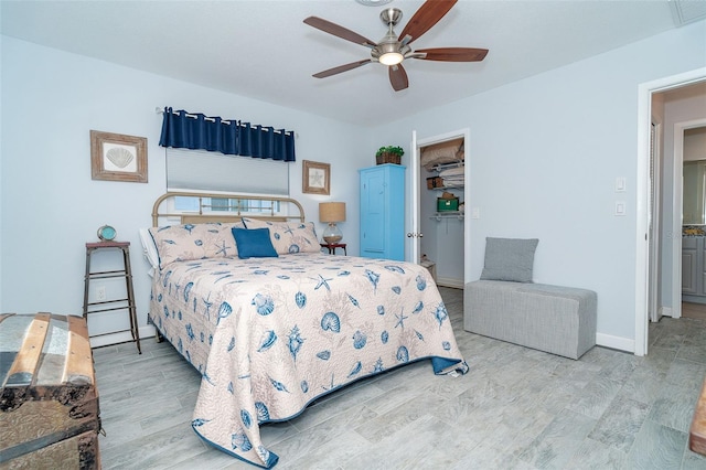 bedroom with light wood-type flooring, ceiling fan, and a closet