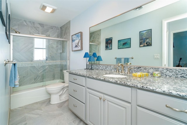 full bathroom featuring toilet, vanity, and bath / shower combo with glass door