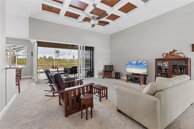 living room with light carpet, coffered ceiling, ceiling fan, a high ceiling, and beam ceiling